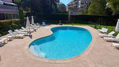 a large swimming pool with lounge chairs and a bunch ofitures at The Noailles - Lovely flat with swimming pool five minutes from the beach in Cannes