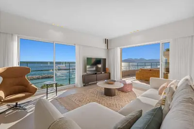 a living room with white furniture and a view of the ocean at REF 2005 Cannes Center Appartment for rent in Cannes