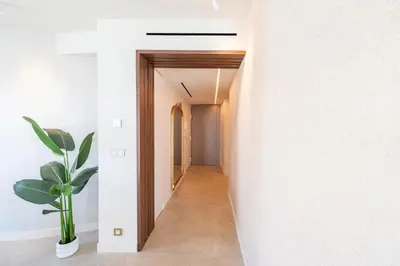 a hallway of a house with white walls and a plant at REF 2005 Cannes Center Appartment for rent in Cannes