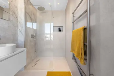 a bathroom with a shower and a yellow towel at REF 2005 Cannes Center Appartment for rent in Cannes