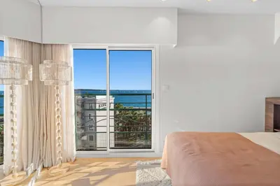 a bedroom with a large window with a view of the ocean at REF 2005 Cannes Center Appartment for rent in Cannes