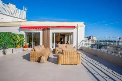 a patio with wicker furniture on a balcony at REF 2005 Cannes Center Appartment for rent in Cannes
