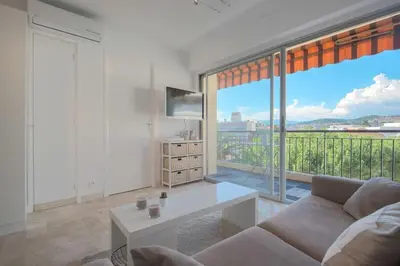 a living room with a couch and a large window at Wdf studio in the heart of Cannes! in Cannes