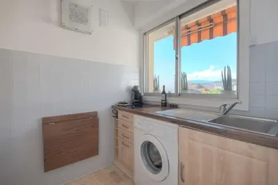a kitchen with a washing machine and a window at Wdf studio in the heart of Cannes! in Cannes