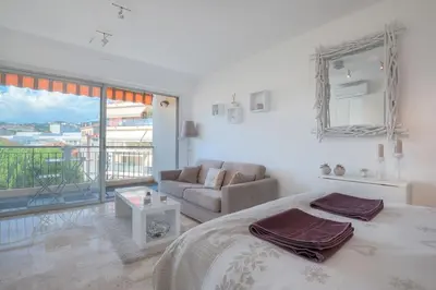 a white bedroom with a bed and a couch at Wdf studio in the heart of Cannes! in Cannes