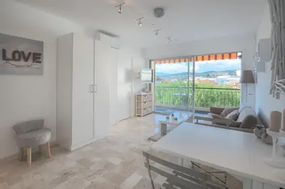 a white living room with a couch and a table at Wdf studio in the heart of Cannes! in Cannes