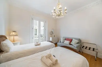 a bedroom with two beds and a chandelier at Truly amazing 3 bedrooms Cannes center!! in Cannes