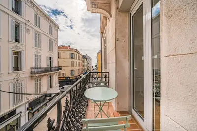 a balcony with a table and a view of a street at Truly amazing 3 bedrooms Cannes center!! in Cannes