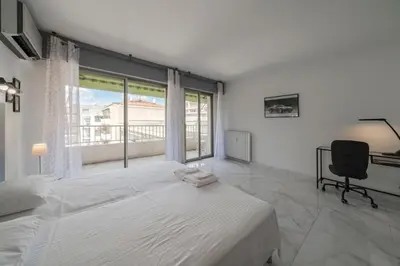 a bedroom with a bed and a chair and a window at Wdf 2 bedrooms heart of Cannes!! in Cannes