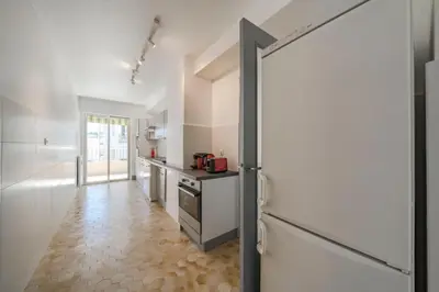 a kitchen with a white refrigerator and a tile floor at Wdf 2 bedrooms heart of Cannes!! in Cannes