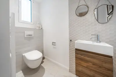 a bathroom with a toilet and a sink and mirrors at Contemporary house in the center of Cannes with a pool and relaxation area in Cannes