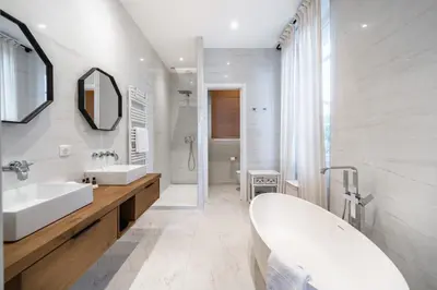 a white bathroom with two sinks and a tub at Contemporary house in the center of Cannes with a pool and relaxation area in Cannes