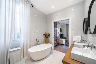 a white bathroom with a large tub and a sink at Contemporary house in the center of Cannes with a pool and relaxation area in Cannes