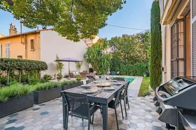 a patio with a table and chairs and a pool at Contemporary house in the center of Cannes with a pool and relaxation area in Cannes