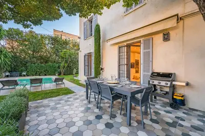 an outdoor patio with a table and a grill at Contemporary house in the center of Cannes with a pool and relaxation area in Cannes
