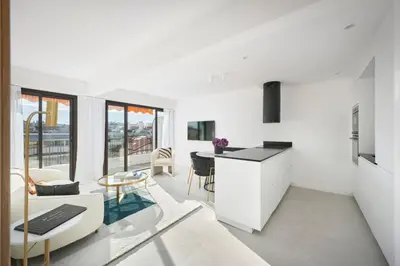 a kitchen and living room with white walls and a table at Wdf 2 bedroom heart of Cannes in Cannes