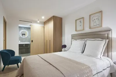 a bedroom with a bed and a blue chair at Wdf 2 bedroom heart of Cannes in Cannes