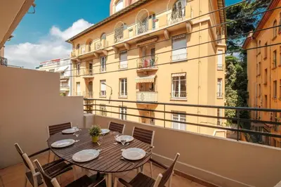 a balcony with a table and chairs and a building at Wonderful 2 bedrooms in the heart of Cannes ! in Cannes