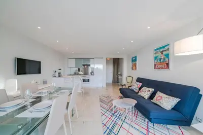 a living room with a blue couch and a table at Wonderful 2 bedrooms with sea view and pool ! in Cannes