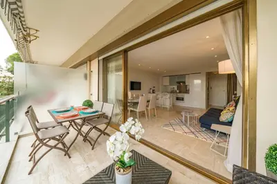 a living room and a dining room with a table and chairs at Wonderful 2 bedrooms with sea view and pool ! in Cannes