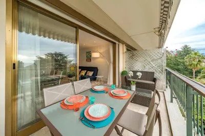 a table and chairs on the balcony of a house at Wonderful 2 bedrooms with sea view and pool ! in Cannes