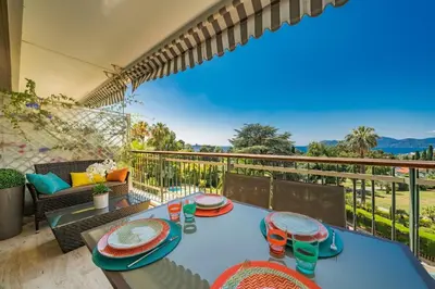 a blue table with plates on it on a balcony at Wonderful 2 bedrooms with sea view and pool ! in Cannes