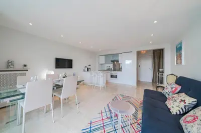 a living room with a blue couch and a dining room at Wonderful 2 bedrooms with sea view and pool ! in Cannes