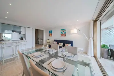 a dining room with a glass table and chairs at Wonderful 2 bedrooms with sea view and pool ! in Cannes