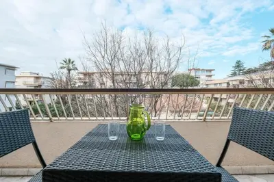 a green glass vase sitting on a table on a balcony at Wonderful 1 bedroom 3 min walk to the Croisette! in Cannes