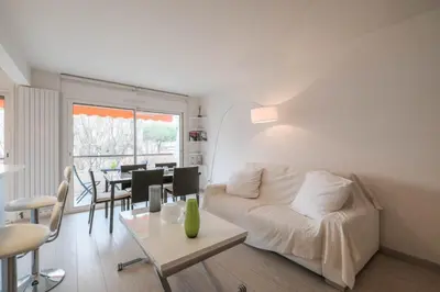a living room with a white couch and a table at Wonderful 1 bedroom 3 min walk to the Croisette! in Cannes