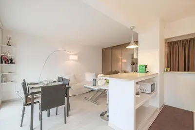 a kitchen and living room with a table and chairs at Wonderful 1 bedroom 3 min walk to the Croisette! in Cannes