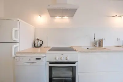 a white kitchen with a stove and a refrigerator at Wonderful 1 bedroom 3 min walk to the Croisette! in Cannes