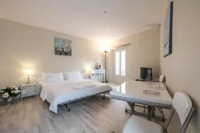 a white bedroom with a bed and a desk at Cozystay 1087 - Charming studio historic Suquet in Cannes