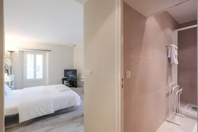 a bedroom with a bed and a walk in shower at Cozystay 1087 - Charming studio historic Suquet in Cannes