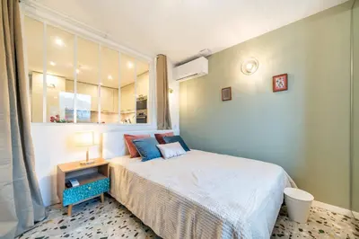 a small bedroom with a bed and a window at Beautiful two bedroom duplex apartment in Cannes