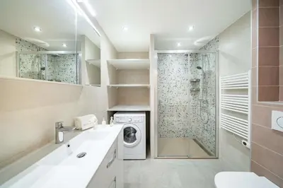a bathroom with a washing machine and a shower at Beautiful two bedroom duplex apartment in Cannes