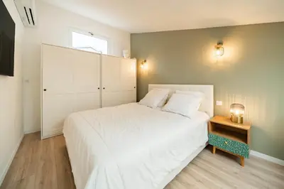 a bedroom with a large white bed and a window at Beautiful two bedroom duplex apartment in Cannes