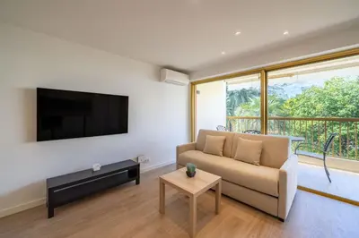 a living room with a couch and a flat screen tv at Beautiful studio with balcony in Cannes in Cannes