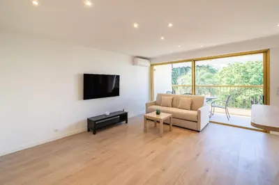 a living room with a couch and a tv on a wall at Beautiful studio with balcony in Cannes in Cannes