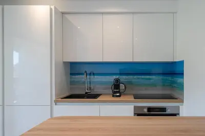 a kitchen with white cabinets and a sink at Beautiful studio with balcony in Cannes in Cannes