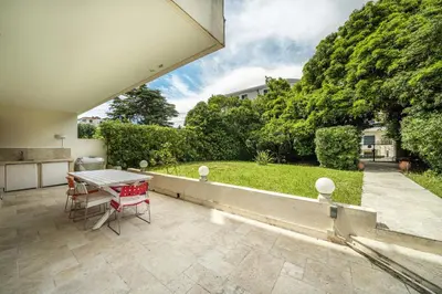 a patio with a table and a view of a yard at Pleasant 2 bedroom with large terrace in Cannes