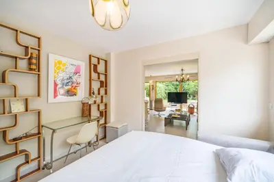 a bedroom with a white bed and a living room at Pleasant 2 bedroom with large terrace in Cannes