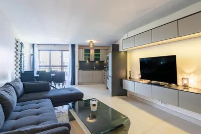 a living room with a blue couch and a tv at 4 pièces sur deux niveaux au cœur de Cannes in Cannes