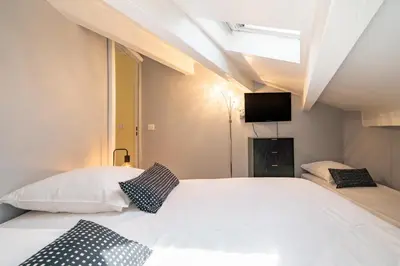 a bedroom with a large white bed with a skylight at 4 pièces sur deux niveaux au cœur de Cannes in Cannes
