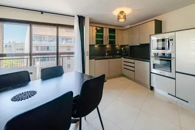 a kitchen with a table and chairs in a room at 4 pièces sur deux niveaux au cœur de Cannes in Cannes