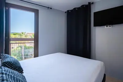 a bedroom with a bed and a large window at 4 pièces sur deux niveaux au cœur de Cannes in Cannes