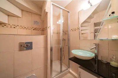 a bathroom with a glass shower and a sink at 4 pièces sur deux niveaux au cœur de Cannes in Cannes
