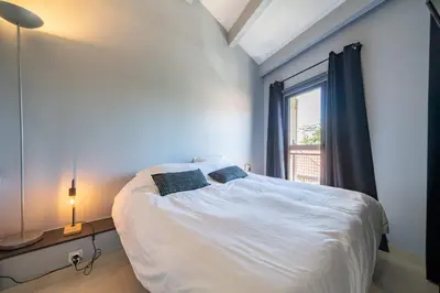 a bedroom with a bed with two pillows on it at 4 pièces sur deux niveaux au cœur de Cannes in Cannes