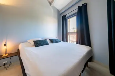 a small bed in a room with a window at 4 pièces sur deux niveaux au cœur de Cannes in Cannes