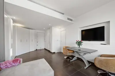 a living room with a table and a tv on a wall at Agréable studio à deux pas de la Croisette in Cannes